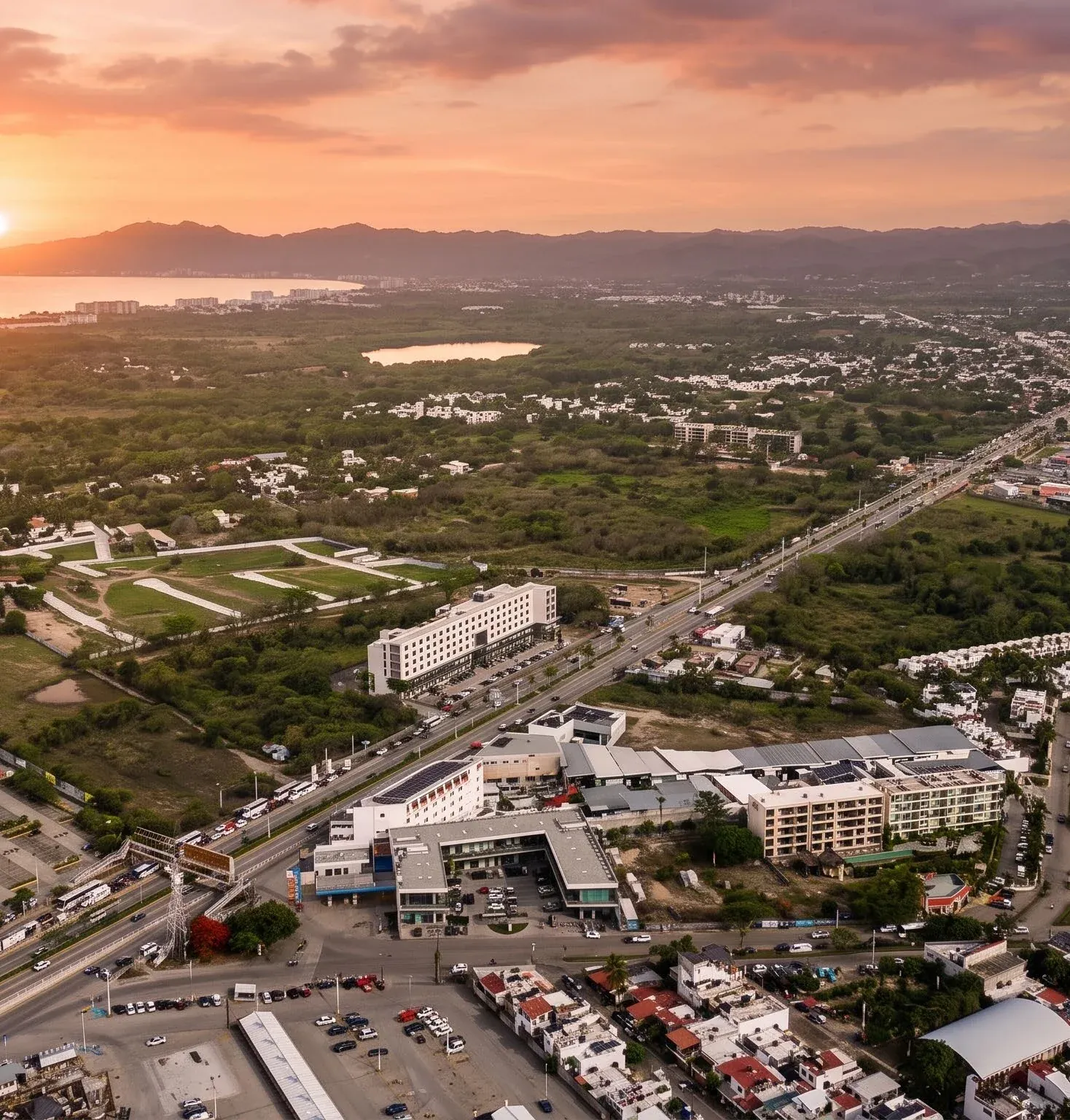 Vista aérea de la bahía al atardecer, con el conjunto médico junto a la avenida principal